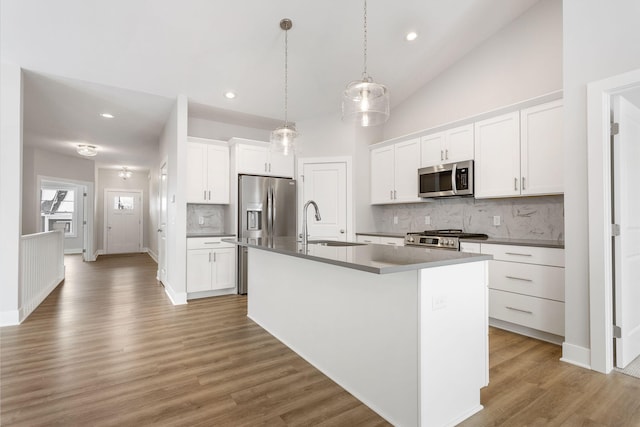 kitchen with sink, an island with sink, white cabinets, and appliances with stainless steel finishes