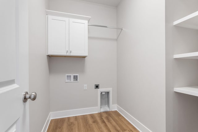 laundry area with hookup for a washing machine, electric dryer hookup, cabinets, and light wood-type flooring