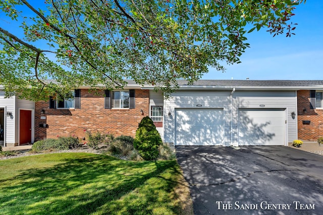 single story home featuring a garage and a front yard