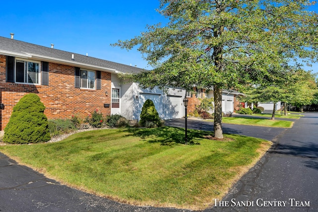 view of front of property featuring a garage and a front lawn