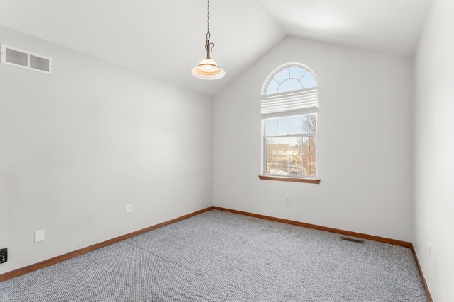 spare room featuring vaulted ceiling and carpet flooring