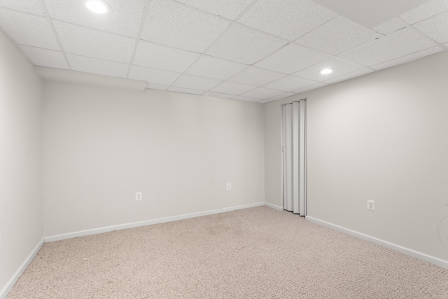 carpeted spare room featuring a paneled ceiling