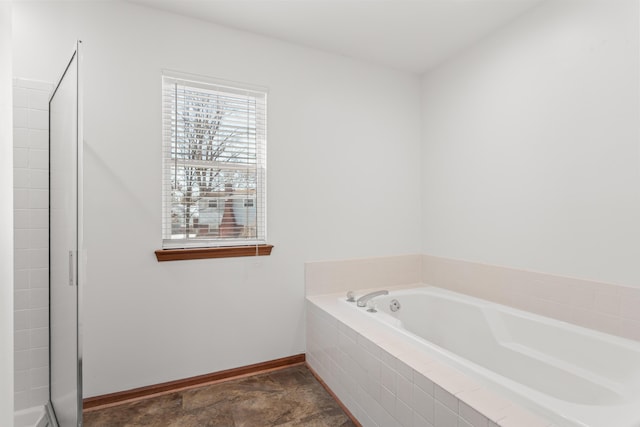 bathroom with a relaxing tiled tub