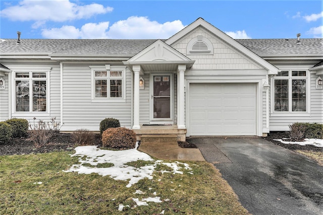 single story home with a garage and a front lawn