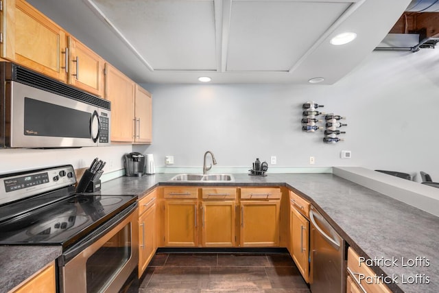 kitchen featuring stainless steel appliances, sink, dark tile patterned flooring, and kitchen peninsula