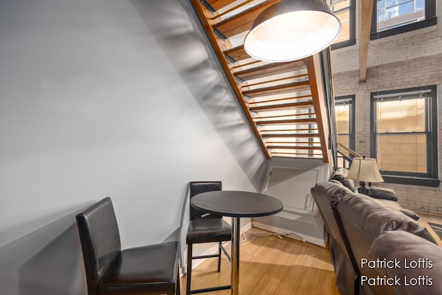 interior space with brick wall, a healthy amount of sunlight, and light hardwood / wood-style flooring