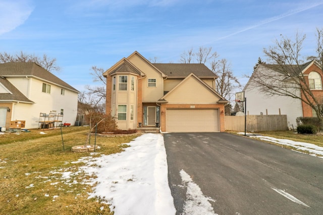 traditional-style home with fence, aphalt driveway, and a front yard