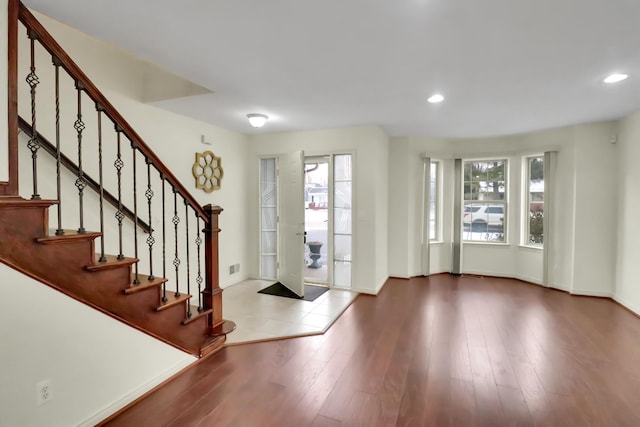 foyer featuring stairs, wood finished floors, baseboards, visible vents, and recessed lighting