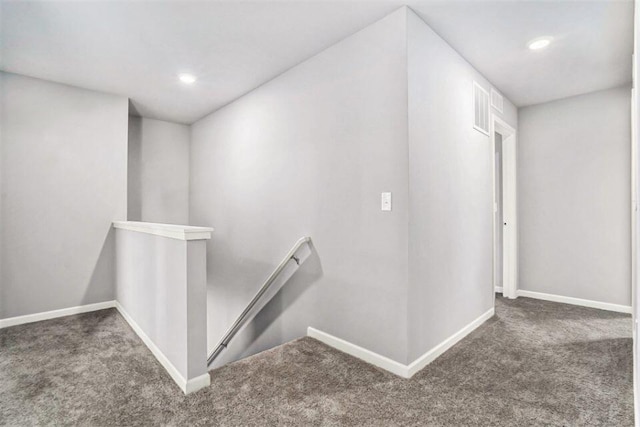 hallway featuring dark colored carpet