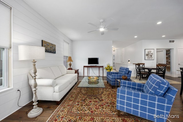 living room featuring dark wood-type flooring and ceiling fan