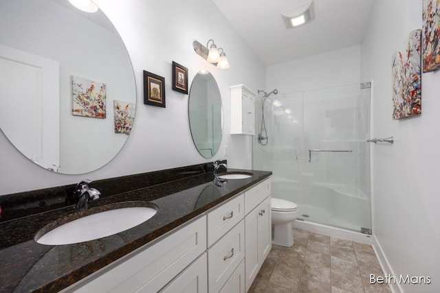 bathroom featuring toilet, vanity, and walk in shower