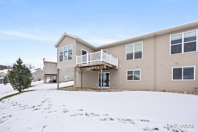 snow covered rear of property featuring a wooden deck