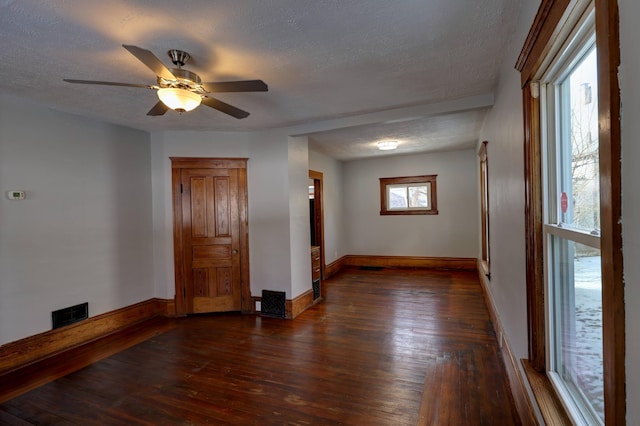 spare room featuring ceiling fan, dark hardwood / wood-style floors, and a textured ceiling