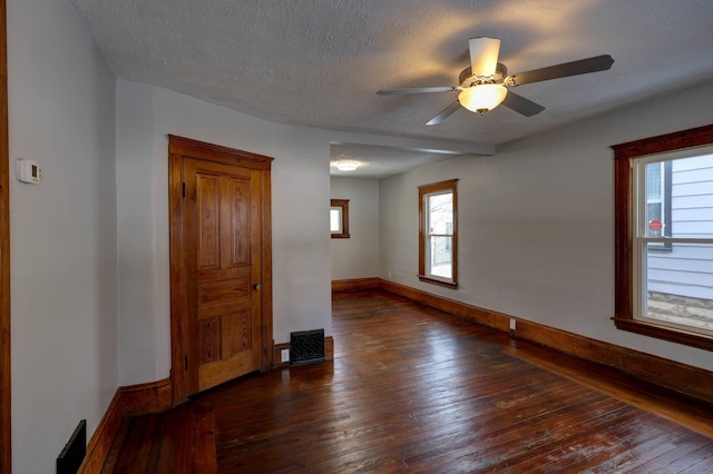 empty room with ceiling fan, dark hardwood / wood-style flooring, and a textured ceiling