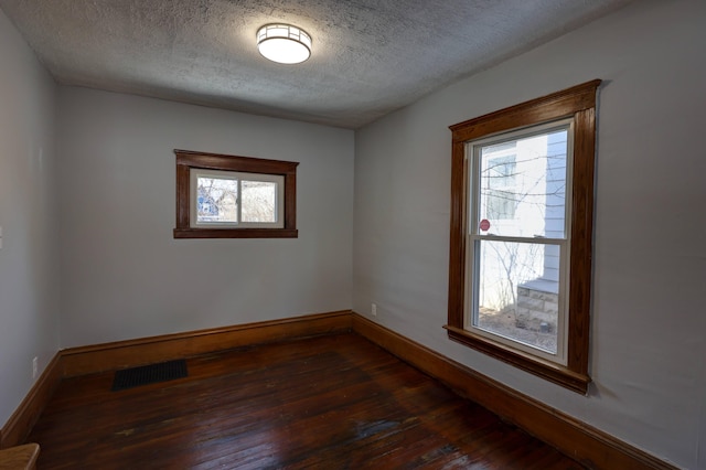 unfurnished room with dark hardwood / wood-style floors and a textured ceiling