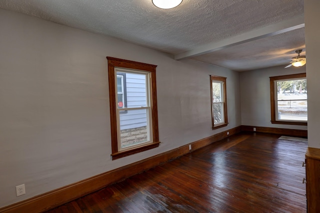 empty room with dark hardwood / wood-style floors and a textured ceiling