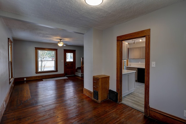 interior space with dark hardwood / wood-style flooring, ceiling fan, and a textured ceiling