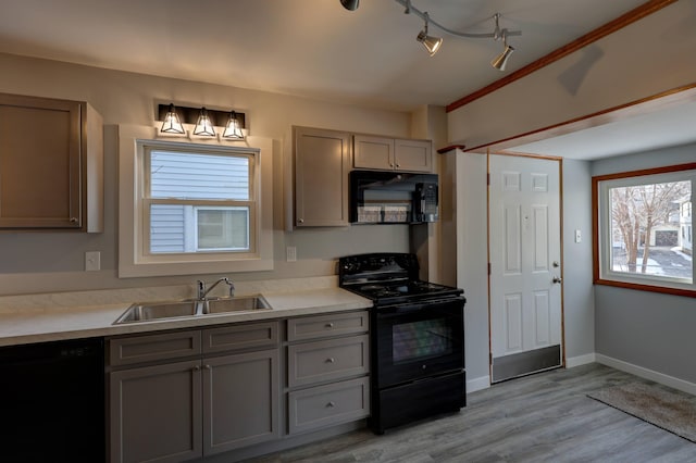 kitchen featuring gray cabinetry, sink, black appliances, and light hardwood / wood-style floors