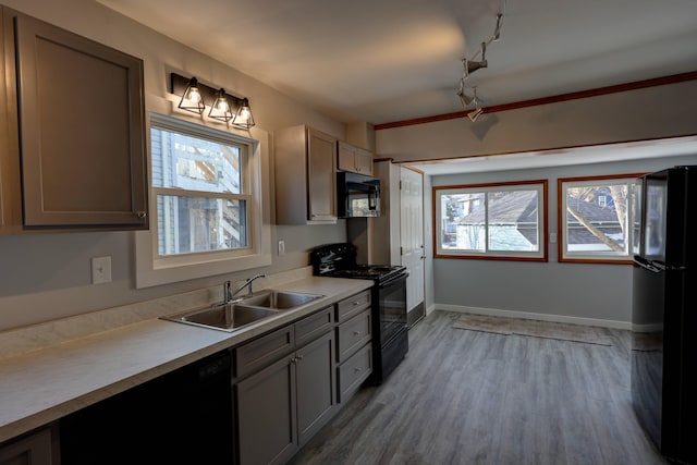 kitchen featuring sink, light hardwood / wood-style flooring, and black appliances