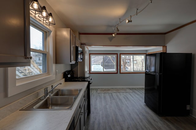 kitchen featuring hanging light fixtures, a healthy amount of sunlight, sink, and black appliances