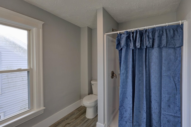 bathroom featuring walk in shower, hardwood / wood-style floors, a textured ceiling, and toilet