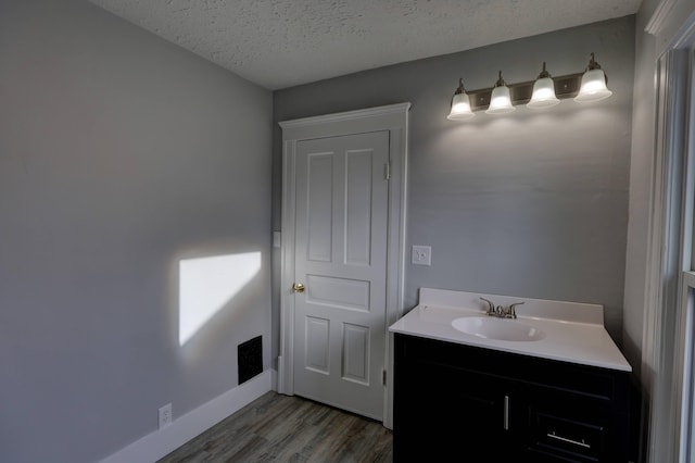 bathroom featuring vanity, hardwood / wood-style floors, and a textured ceiling