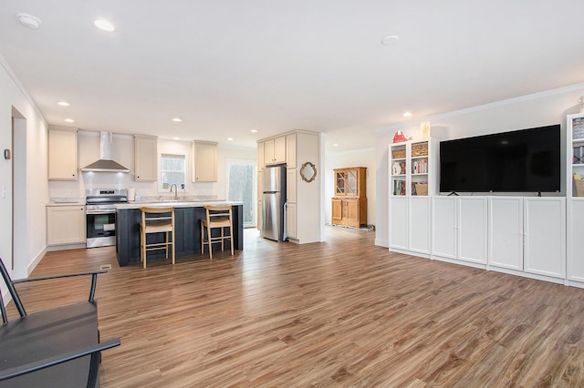 living room with ornamental molding, sink, and light hardwood / wood-style flooring