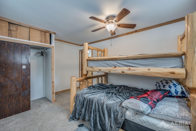 carpeted bedroom featuring ceiling fan, ornamental molding, and a closet