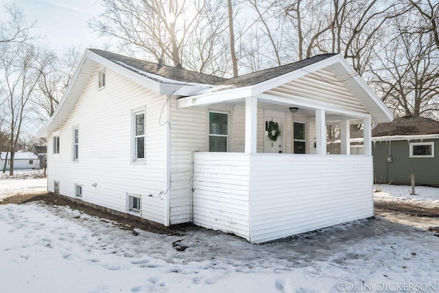 view of snow covered exterior featuring covered porch