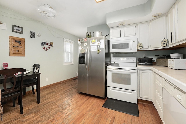 kitchen with white cabinetry, white appliances, tile countertops, and light hardwood / wood-style flooring