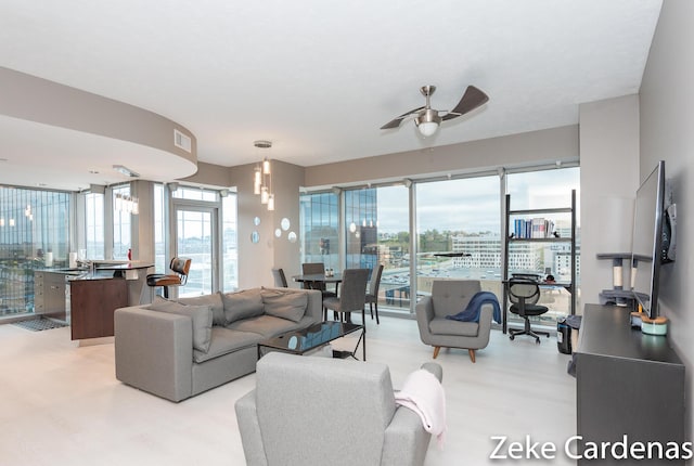 living room featuring ceiling fan, a wealth of natural light, and light hardwood / wood-style floors