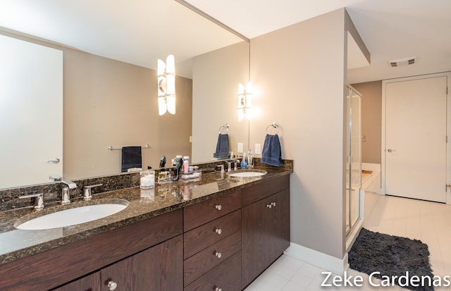 bathroom featuring tile patterned flooring, vanity, and walk in shower