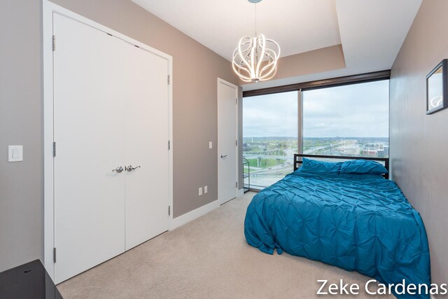 carpeted bedroom with an inviting chandelier and access to outside