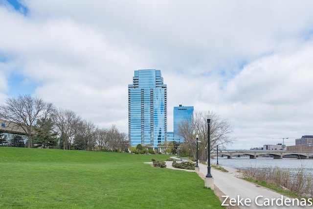 view of property's community with a water view and a lawn