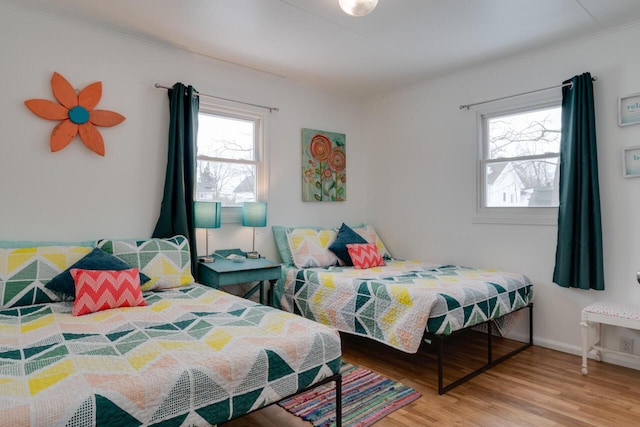 bedroom with multiple windows and hardwood / wood-style floors