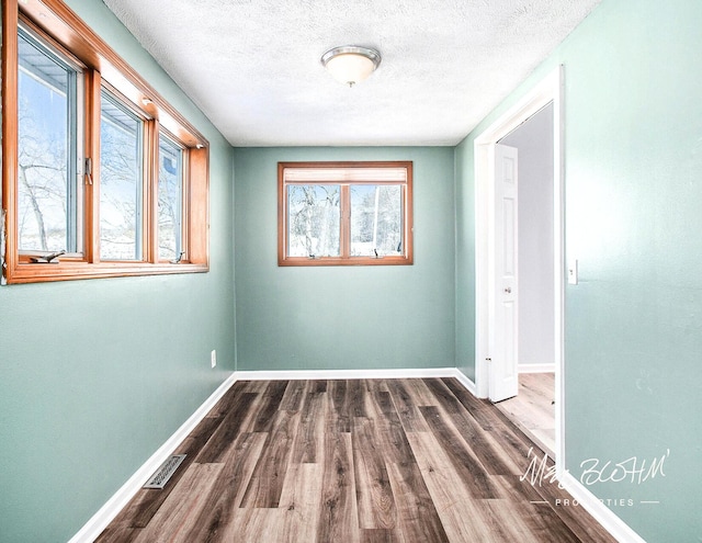 unfurnished room featuring hardwood / wood-style floors and a textured ceiling