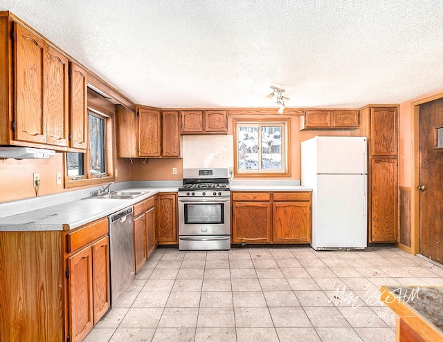 kitchen with a healthy amount of sunlight, stainless steel appliances, and a textured ceiling