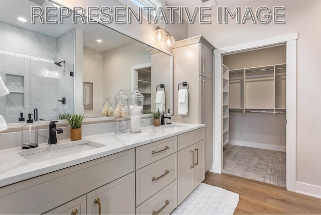 bathroom with vanity, hardwood / wood-style flooring, and a shower with door