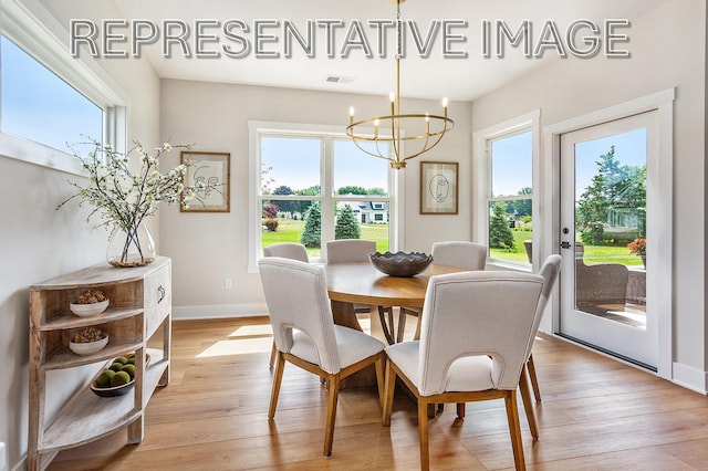 dining area featuring light hardwood / wood-style flooring and a notable chandelier