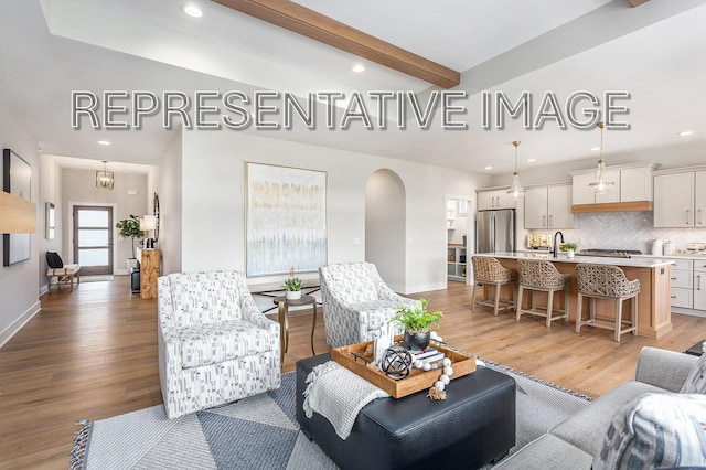 living room with beamed ceiling and light hardwood / wood-style flooring