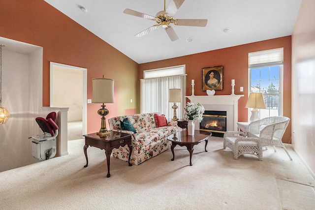 living room featuring ceiling fan, lofted ceiling, a tile fireplace, and carpet