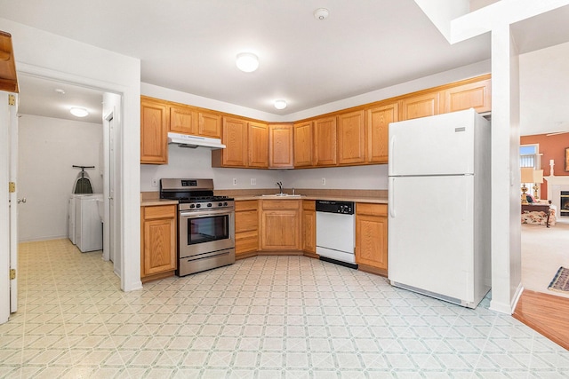 kitchen featuring separate washer and dryer, sink, and white appliances