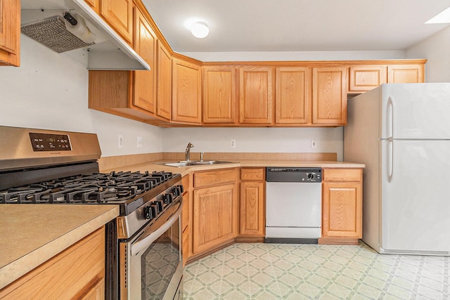 kitchen with dishwashing machine, sink, gas stove, and white refrigerator