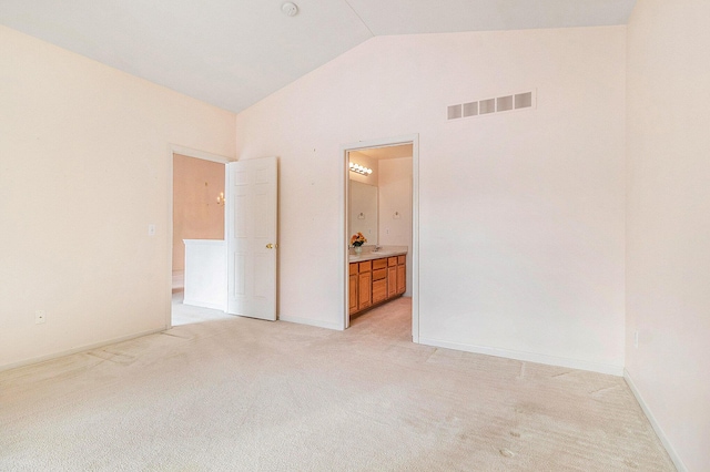 unfurnished room with lofted ceiling and light carpet