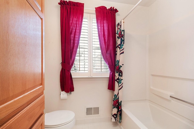 bathroom featuring shower / tub combo and toilet