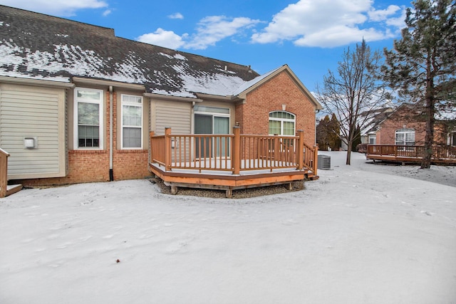 snow covered house featuring a wooden deck