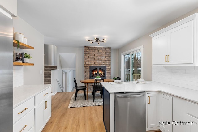 kitchen featuring white cabinetry, dishwasher, backsplash, kitchen peninsula, and light wood-type flooring