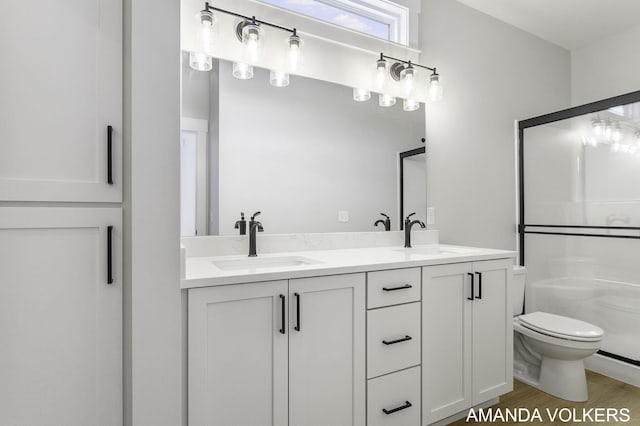 bathroom featuring hardwood / wood-style flooring, vanity, walk in shower, and toilet