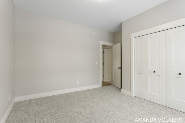 unfurnished bedroom featuring a closet and light carpet