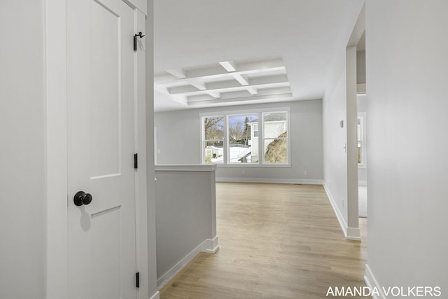 corridor featuring beam ceiling, coffered ceiling, and light hardwood / wood-style floors